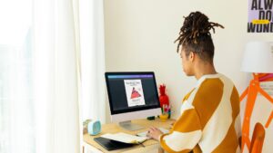 A man looking at a computer screen and creating a design
