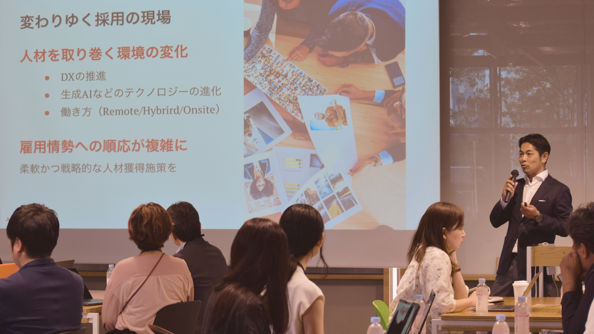 講演会の壇上でスライドに沿って説明をするスピーカー杉本隆一郎代表
