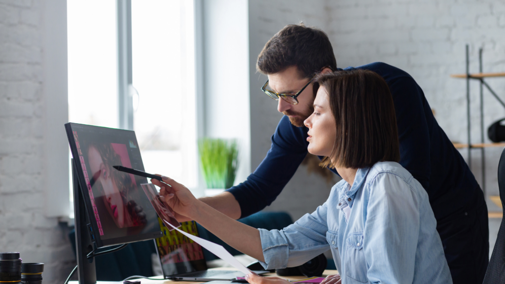 ディレクターがデザイナーの作品を確認し、デザイナーに指示を出している様子